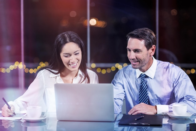 Businessman discussing with colleague over laptop