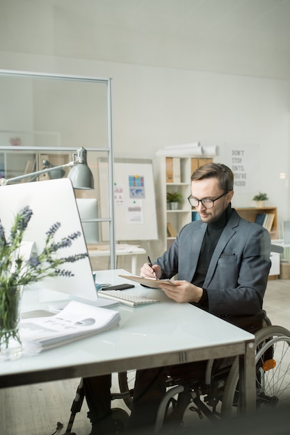 Uomo d'affari che fa lavoro di ufficio all'ufficio