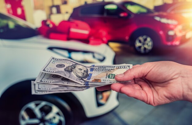 Businessman doing purchase or rent car giving dollar salesman