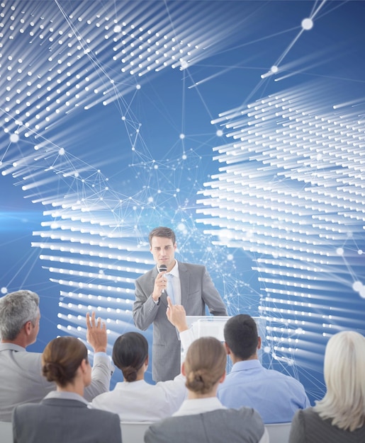 Businessman doing speech during meeting  against glowing world map on black background