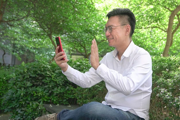 Businessman doing video chat using his smartphone outdoors