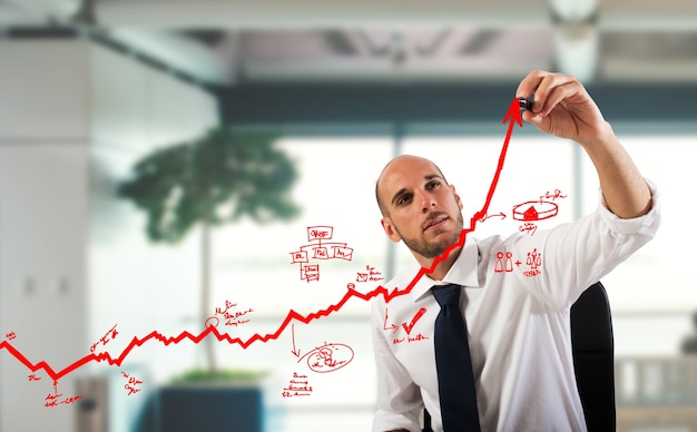 Imprenditore disegnare grafici su una freccia in salita