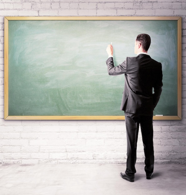 Businessman drawing on a blackboard