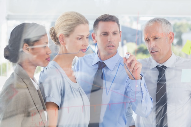 Businessman drawing graph on the glass