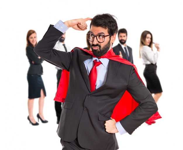 Businessman dressed like superhero thinking over white