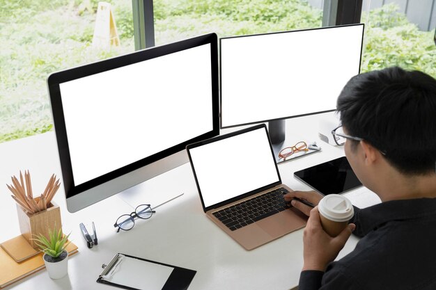 Businessman drinking coffee and working with multiple modern devices