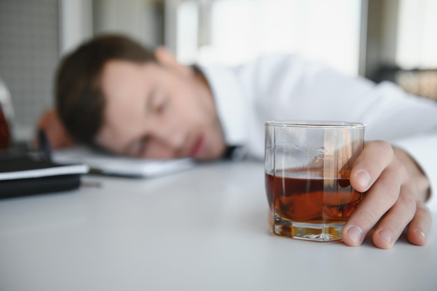 Businessman drinking from stress at workplace