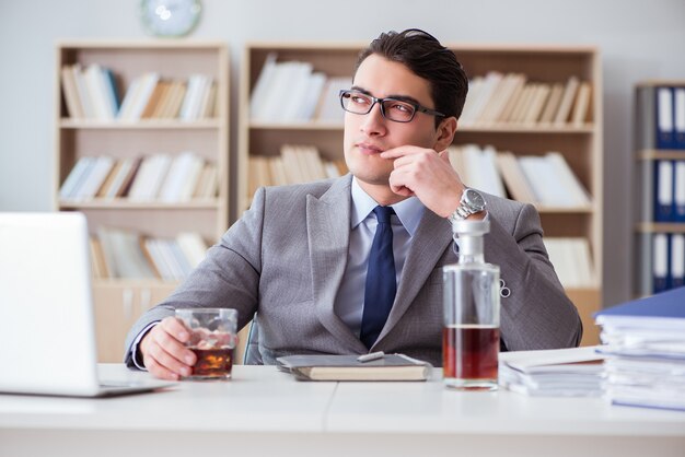 Uomo d'affari che beve in ufficio