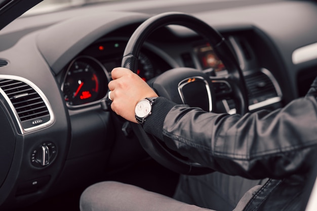 Businessman driving luxury modern car in the city