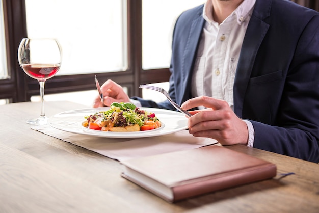 Uomo d'affari che mangia durante un pranzo di lavoro in ristorante.