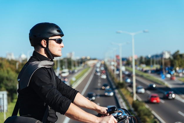 橋の上を運転する電動自転車のビジネスマン