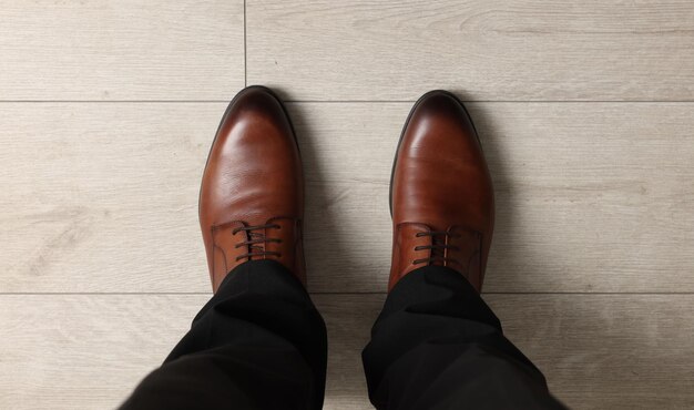 Businessman in elegant leather shoes on floor above view