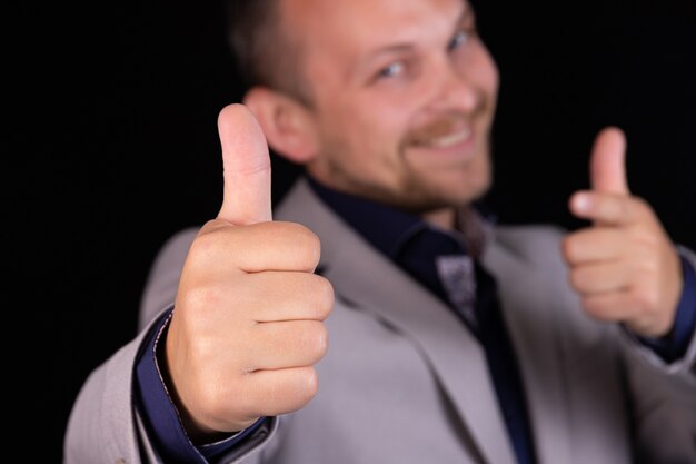 Photo businessman, engineer in a gray suit on a black background points a finger at the text. business idea, concept.