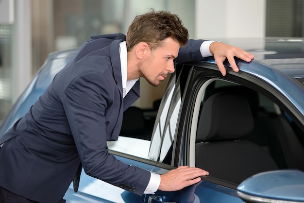 Businessman examining a car at the dealership.