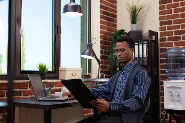 Photo businessman examining reports at office