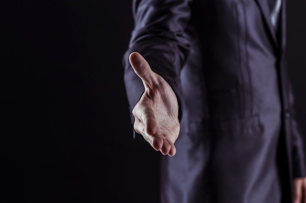 businessman extends his hand forward for a handshake.