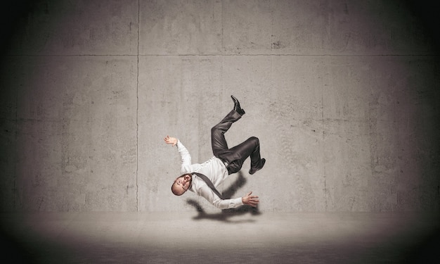 Businessman falling on concrete background.