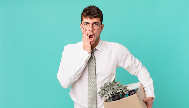 Businessman feeling shocked and scared, looking terrified with open mouth and hands on cheeks. dismissal concept