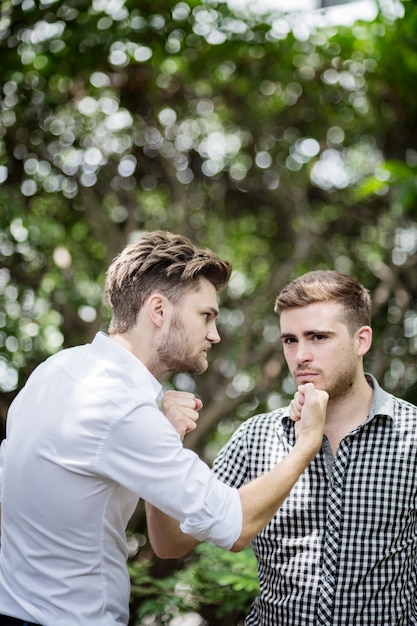 businessman fight and punch in garden business competition concept