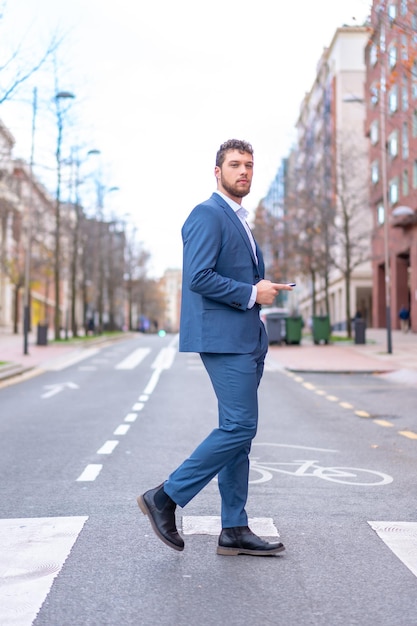 Businessman or finance man crossing a zebra crossing near the hotel he is staying in young entrepreneur concept