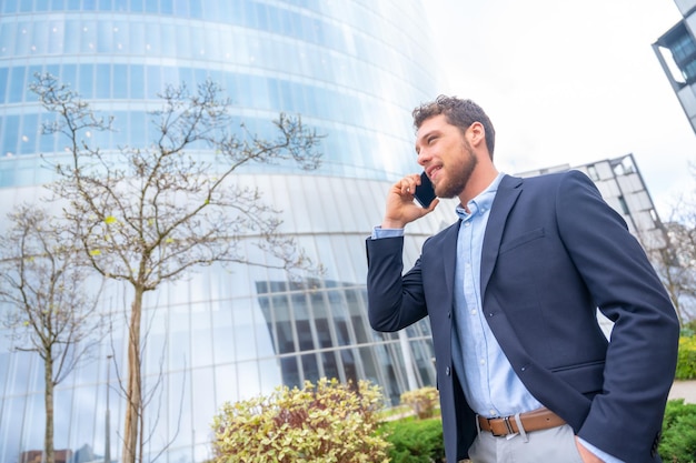 Businessman or finance man talking on the phone outside the office business park