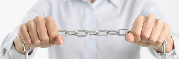 Businessman firmly holds chrome chain in hands women in business concept