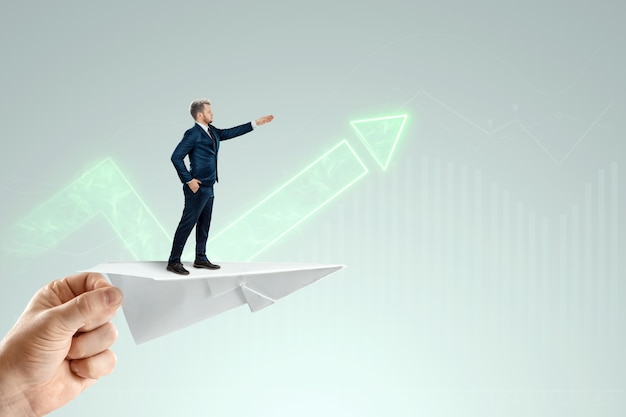 Businessman flying on a paper airplane with the pushing hand of an investor