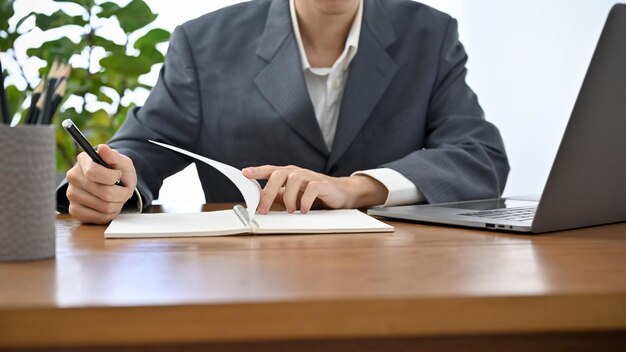 businessman in formal suit working at his office desk checking and reviewing paperwork