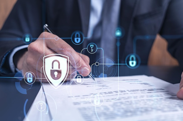 A businessman in formal wear signing the contract to prevent probability of risks in cyber security Padlock Hologram icons over the working desk