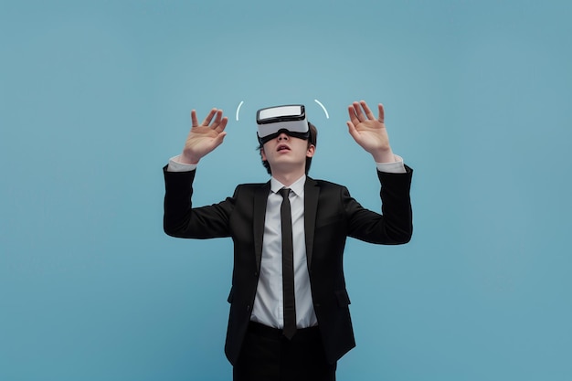 Businessman in a formal wear wearing virtual reality glasses opened his mouth in surprise