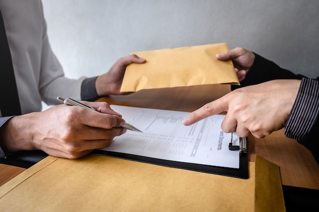 Businessman giving an envelope to businessman