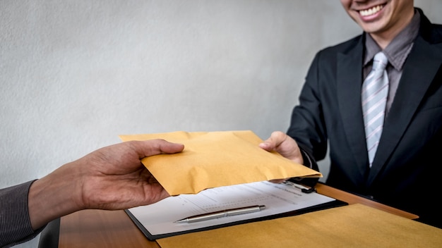 Businessman giving an envelope to businessman