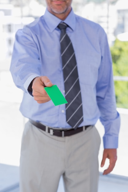 Businessman giving green business card