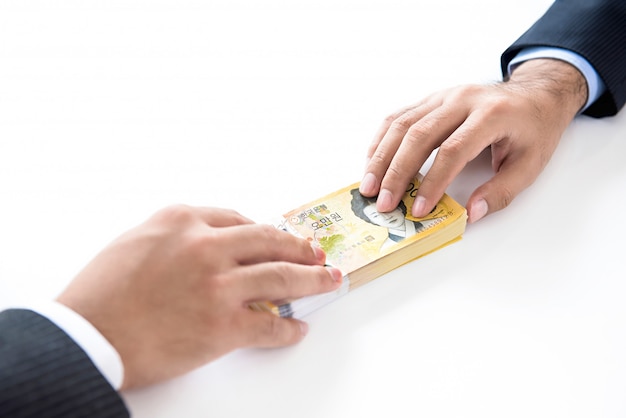 Businessman giving money, South Korean WON currency, to his partner 