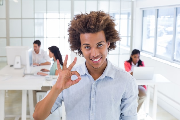 Businessman giving OK gesture to camera