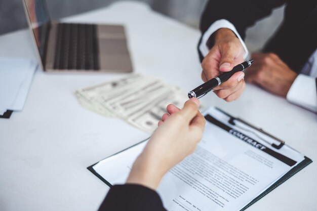 銀行融資契約に署名するために実業家にペンを与える実業家
