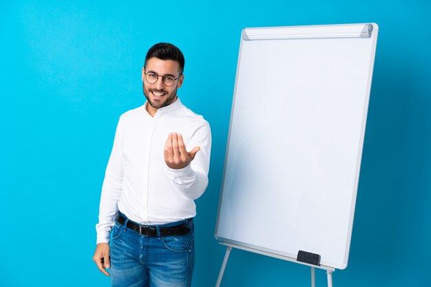 Businessman giving a presentation on white board giving a presentation on white board and inviting to come with hand