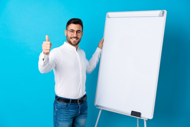 Businessman giving a presentation on white board giving a presentation on white board with thumb up