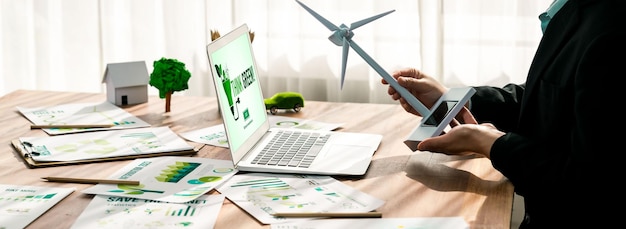 Photo businessman in green corporate company planning ecofriendly and environmental conservative to reduce co2 and implement net zero policy in meeting room with eco idea on laptop screen trailblazing