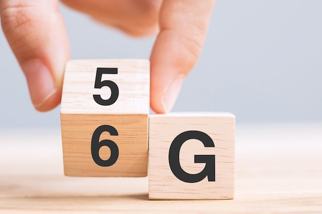 Рука бизнесмена меняет деревянный блок с 5G на 6G (Поколение сотовой мобильной связи) Технологии, сети, социальные сети и цифровые концепции