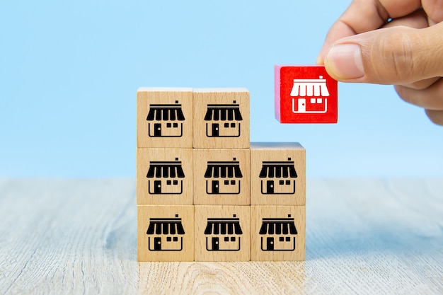 Businessman hand choose wooden block with franchise marketing icons