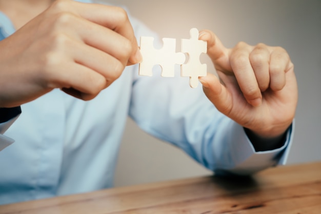 Businessman hand connecting jigsaw puzzle. 