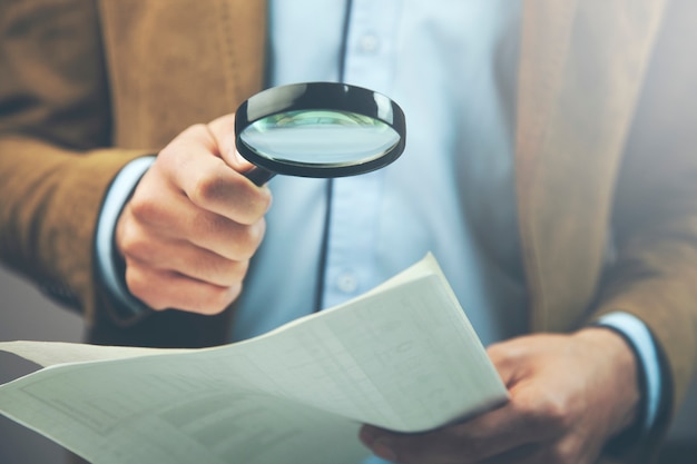 Businessman hand document and magnifier