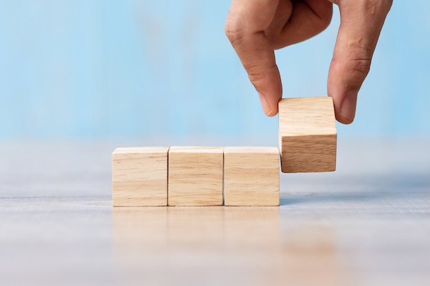 Businessman hand flipping wooden block on table