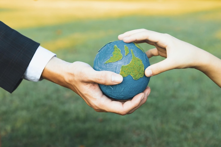 Photo businessman hand giving earth globe to little boy as earth day concept gyre