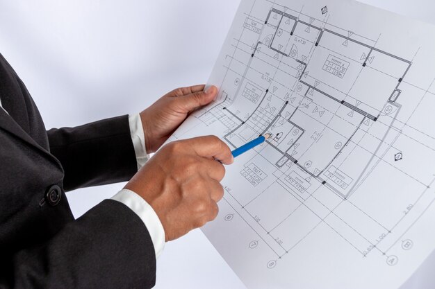 手にビジネスマンは、建設計画または建築計画を持っています