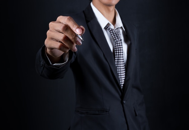 Businessman hand hold pen on black background