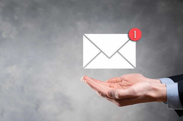 Businessman hand holding e-mail icon, Contact us by newsletter email and protect your personal information from spam mail. Customer service call center contact us concept.