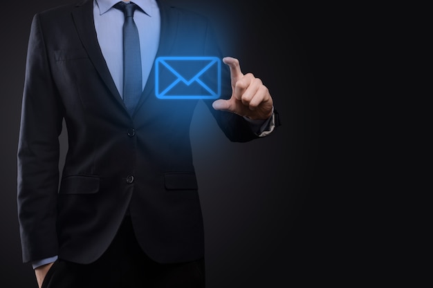 Businessman hand holding e-mail icon, Contact us by newsletter email and protect your personal information from spam mail. Customer service call center contact us concept.