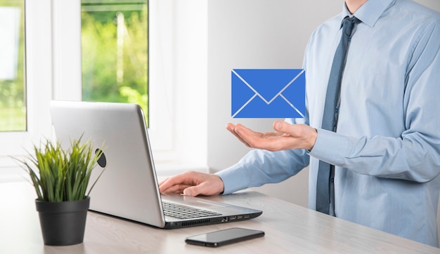 Businessman hand holding e-mail icon, Contact us by newsletter email and protect your personal information from spam mail. Customer service call center contact us concept.